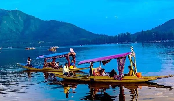 Colourful covered boat on blue water, with hills in the background